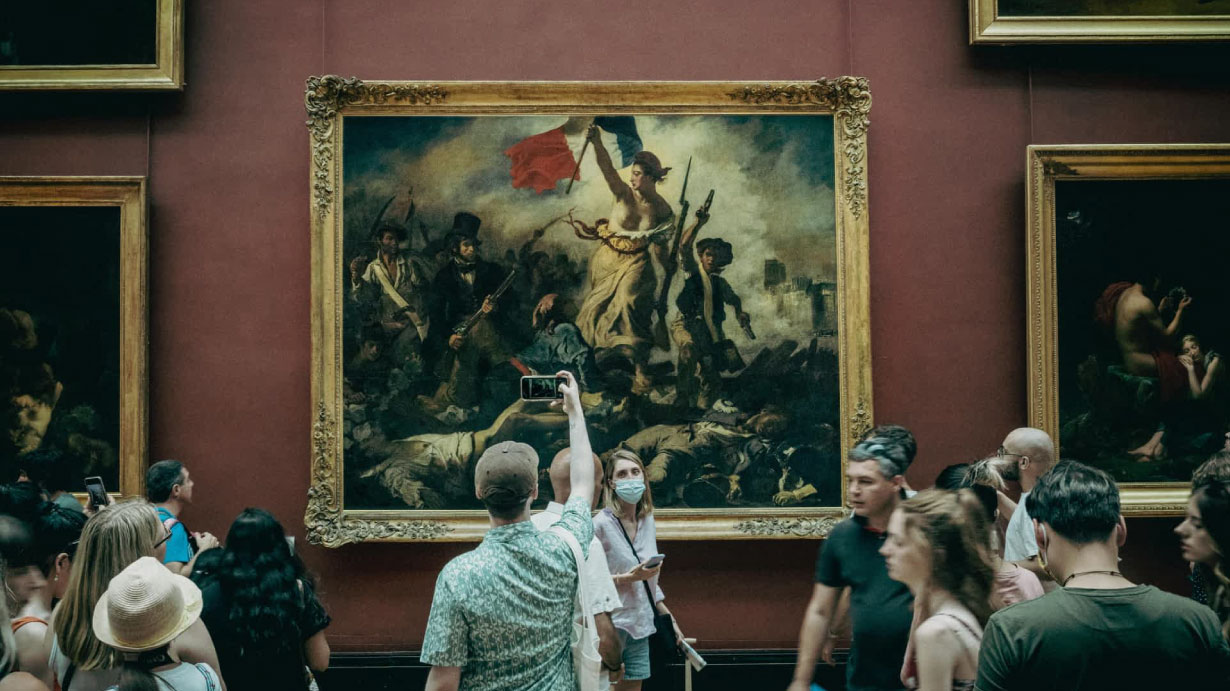 Público observando una pintura histórica en una galería de arte