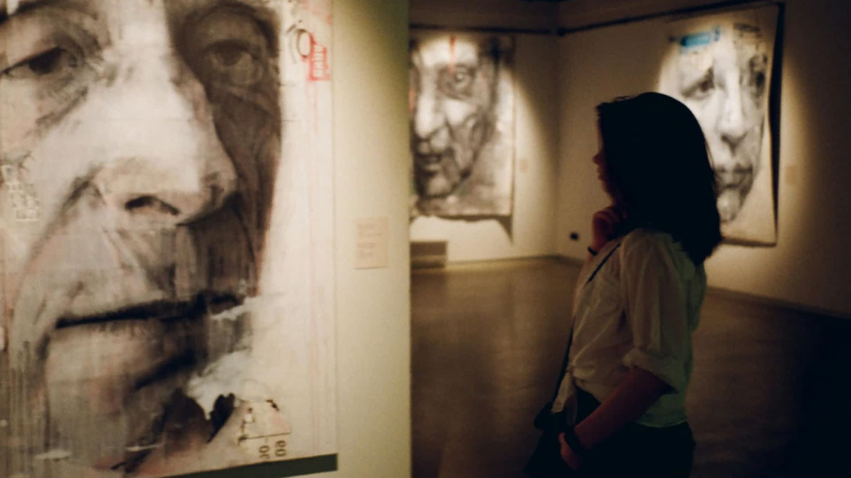 Sala de museo con visitantes explorando una obra representativa del arte clásico